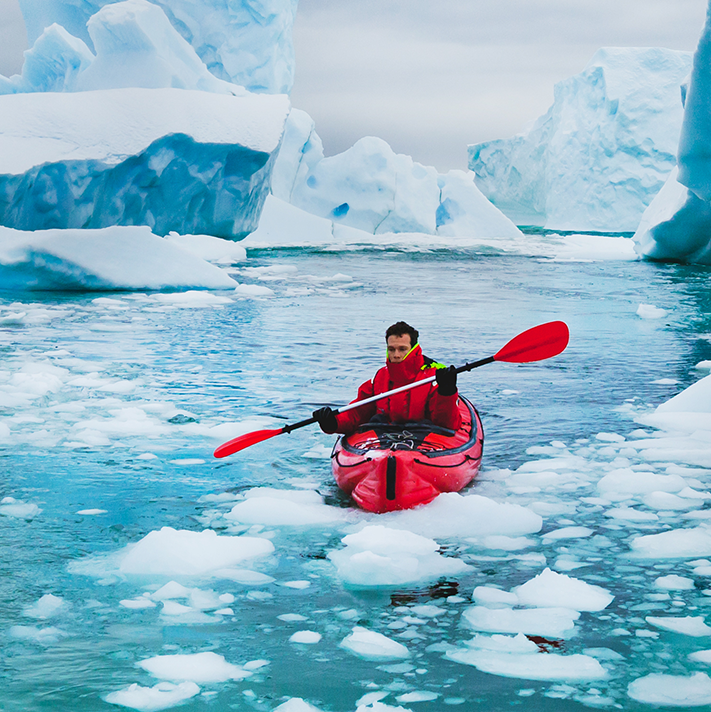 Man glacier kayaking in a red ice kayak