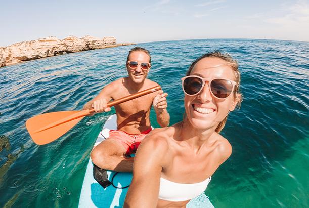 An adult couple paddle boarding on vacation