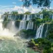 Lush greenery adorn the rocks in the Iguazu Falls waterfall in South America